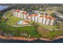 Aerial view of lakefront condo buildings featuring a swimming pool and lush landscaping at 16300 County Road 455 # 704, Montverde, FL 34756