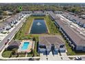 Aerial view of a townhome community featuring a pool, pond with fountain, landscaping, and neatly arranged residential buildings at 2037 Canny Cv, Winter Park, FL 32792