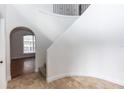 Open entryway with tile flooring leading to hardwood, arched doorway, and staircase with white walls at 2217 Wekiva Reserve Blvd, Apopka, FL 32703