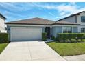 Inviting single-story home boasts a two-car garage, manicured lawn and well-maintained landscaping at 297 Citrus Isle Loop, Davenport, FL 33837