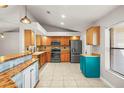 Spacious kitchen featuring sleek, black appliances, warm wooden cabinets and a stylish breakfast bar at 3093 S Horizon Pl, Oviedo, FL 32765