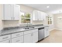 Modern kitchen featuring stainless steel dishwasher, granite countertops, and white cabinets at 321 Ferdinand Dr, Longwood, FL 32750