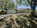 Inviting single-Gathering home featuring mature trees, well-maintained lawn, and two-car garage at 3548 Picciola Cutoff Rd, Fruitland Park, FL 34731