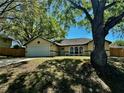 Attractive single-story home with a well-manicured lawn, mature trees, and a two-car garage at 3548 Picciola Cutoff Rd, Fruitland Park, FL 34731