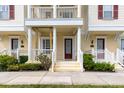 Townhome exterior with red front door, decorative columns, and landscaped yard at 378 Blue Bayou Ln, Winter Springs, FL 32708