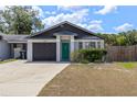 Well-maintained single-story home featuring a dark garage door and a cozy front yard at 4458 Goldenrain Ct, Orlando, FL 32808