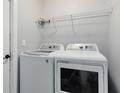 Bright laundry room featuring modern, front-load washer and dryer with ample shelving for storage at 4458 Goldenrain Ct, Orlando, FL 32808
