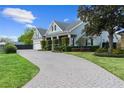 Charming home with a well-manicured lawn, brick driveway, and inviting curb appeal at 5215 Phillips Oaks Ln, Orlando, FL 32812