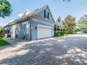 View of home with attached garage and brick paver driveway, showcasing home exterior at 5215 Phillips Oaks Ln, Orlando, FL 32812