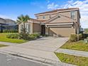 Charming two-story home with a tile roof, green lawn, and attached two-car garage at 7805 Oak Reflection Loop, Davenport, FL 33837