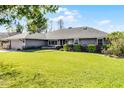 Well-maintained front yard featuring a lush green lawn and neatly trimmed hedges surrounding a gray home at 8992 Palos Verde Dr, Orlando, FL 32825