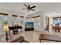 Bright living room with tile floors, ceiling fan, and large windows with wood blinds at 10081 Cobalt Bay Rd, Orlando, FL 32827