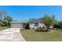 Charming single-story home boasting an oversized driveway, a lush lawn, and vibrant landscaping at 1021 Mare Bello Dr, Winter Park, FL 32792