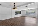 Spacious living room featuring hardwood floors, large windows and an ornate chandelier at 1021 Mare Bello Dr, Winter Park, FL 32792