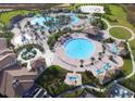 Stunning aerial view of the community's resort-style pool, water park, and recreation area, surrounded by lush landscaping at 1106 Kingsbarn St, Davenport, FL 33896