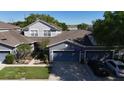 Aerial view of the property shows a well-maintained gray home, neat landscaping, and a spacious driveway at 1247 Travertine Ter, Sanford, FL 32771