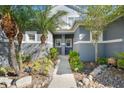 Inviting front entrance with landscaped walkway, mature palms, and tasteful exterior lighting at 1247 Travertine Ter, Sanford, FL 32771