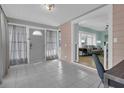 Entryway featuring tiled floors, views into the living room, and a front door with half-round window at 1407 E Kaley St, Orlando, FL 32806