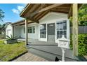 Close up of the home's covered front porch, entry door, mailbox, and a partial view of the yard at 1407 E Kaley St, Orlando, FL 32806