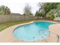 Backyard pool surrounded by concrete deck and a well-maintained wooden privacy fence at 1505 Guinevere Dr, Casselberry, FL 32707