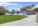 Single-story home with a driveway leading to a detached garage, surrounded by a well-kept lawn at 1610 Stephanie Ln, Lakeland, FL 33813