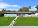 Well-maintained single-story home with a green front yard, concrete walkway and decorative flower beds at 1610 Stephanie Ln, Lakeland, FL 33813