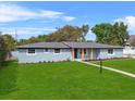 Inviting single-story home featuring a lush front lawn, complemented by neatly arranged flower beds at 1610 Stephanie Ln, Lakeland, FL 33813