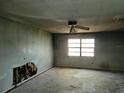 Empty living room featuring a window and ceiling fan, ready for renovation at 1838 Windmill Dr, Orlando, FL 32818