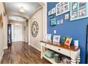 Inviting foyer with wood-look tile flooring, an accent wall with Gathering photos, and console table decor at 2300 Natoma Blvd, Mount Dora, FL 32757