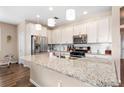 Spacious kitchen with stainless steel appliances, white cabinets, granite countertops, and wood-look flooring at 2300 Natoma Blvd, Mount Dora, FL 32757