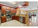 Well-equipped kitchen featuring stainless steel appliances, granite countertops, and cherry wood cabinets at 2864 Polana St # 104, Orlando, FL 32835