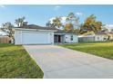 Exterior shot of a well-maintained single-story home featuring a spacious driveway and a manicured front lawn at 3176 Sw 127Th St, Ocala, FL 34473