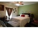 Comfortable bedroom with white comforter, decorative pillows, flower wall decor and green accent wall at 3334 Fawnwood Dr, Ocoee, FL 34761