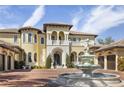 Elegant home featuring a prominent fountain, a grand entrance, and a circular brick driveway at 3402 Cocard Ct, Windermere, FL 34786