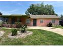 A well-lit, one-story home with a lush green lawn and a concrete driveway at 4845 Elese St, Orlando, FL 32811