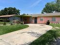 Charming one-story home featuring a covered porch and a long concrete driveway at 4845 Elese St, Orlando, FL 32811