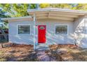 Close-up of the home's charming red front door, complemented by manicured landscaping at 4906 Cortez Dr, Orlando, FL 32808