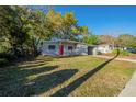 Single-Gathering home with a well-manicured lawn, mature trees, and a partially brick driveway at 4906 Cortez Dr, Orlando, FL 32808