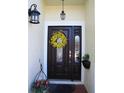 Close up of a stained wood front door with sidelight and decorative wreath at 506 Freeman St, Longwood, FL 32750