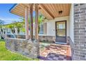 Inviting front porch with brick accents, tiled flooring, and decorative columns at 7529 Winter Shade Dr, Orlando, FL 32822