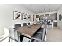 Modern dining area with sleek table, stylish chairs, and contemporary art in an open-concept living space at 7740 Sandy Ridge Dr # 136, Reunion, FL 34747