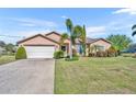 Charming single Gathering home with a two-car garage and beautiful landscaping with green grass and palm trees at 789 Kangaroo Ct, Deltona, FL 32738