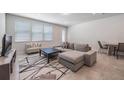 Bright living room with neutral tones, plush sectional, and modern rug, creating a cozy space at 9732 Brown Burrow St, Orlando, FL 32829