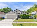 Charming single-story home featuring a well-maintained front yard and a two-car garage at 1028 Henson Ct, Oviedo, FL 32765