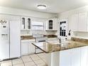 Well-lit kitchen featuring white cabinets, sleek countertops, and functional design elements at 10631 Deergrass Ln, Orlando, FL 32821