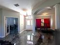 Wide angle of the foyer featuring epoxy floors, and columns creating an open space at 10912 Smokey Ridge Ct, Clermont, FL 34711