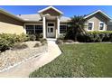 Inviting front yard with lush green lawn and a walkway leading to the front door, surrounded by well-maintained landscaping at 10912 Smokey Ridge Ct, Clermont, FL 34711