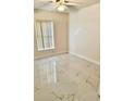 Serene bedroom showcasing light, neutral walls, a window with blinds, and sleek tile flooring at 12526 Ringwood Ave, Orlando, FL 32837