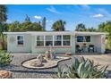 Charming single-story home featuring decorative rock landscaping, multiple windows, and an inviting front patio with seating at 134 Roberta Rd, Ormond Beach, FL 32176