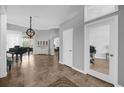 Living room showcasing tile floors, gray walls, grand piano, chandelier, and white china cabinet at 1415 Crocus Ct, Longwood, FL 32750